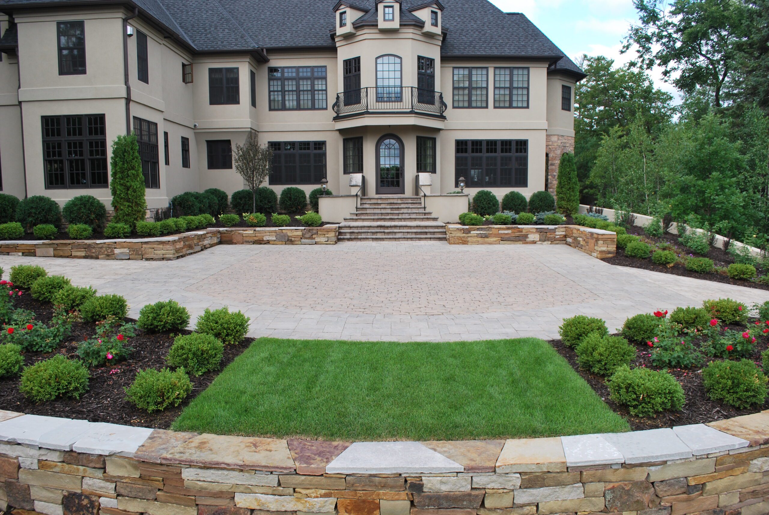 Large custom paver courtyard and driveway design for a luxury estate with tiered stone retaining walls - Yellow Brick Road Pavers & Landscapes LLC