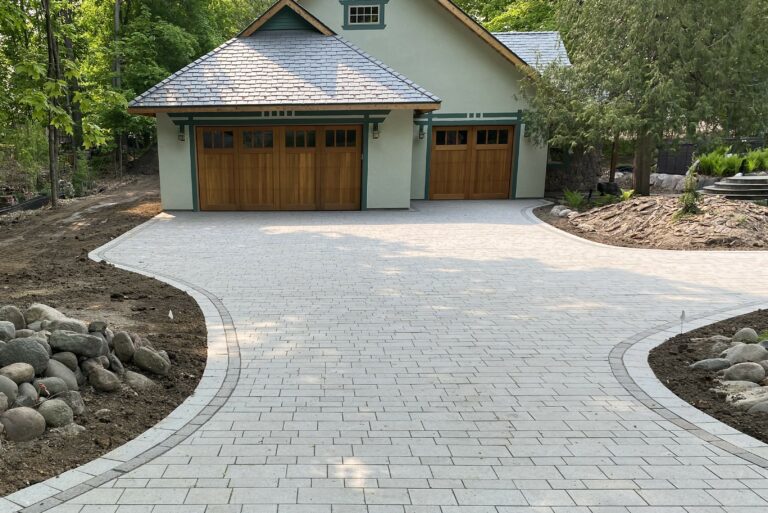 exterior of a home with a paved driveway and custom landscaping - Yellow Brick Road Pavers & Landscapes LLC
