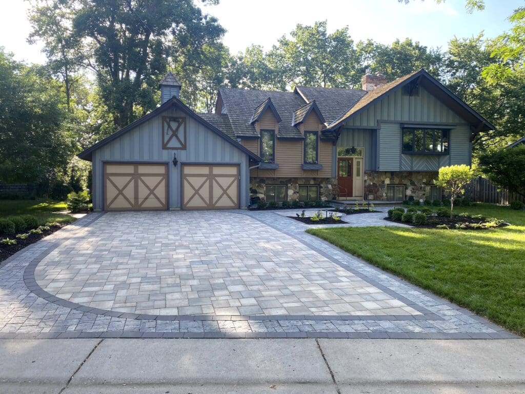 exterior of a home with a paved driveway and custom landscaping - Yellow Brick Road Pavers & Landscapes LLC