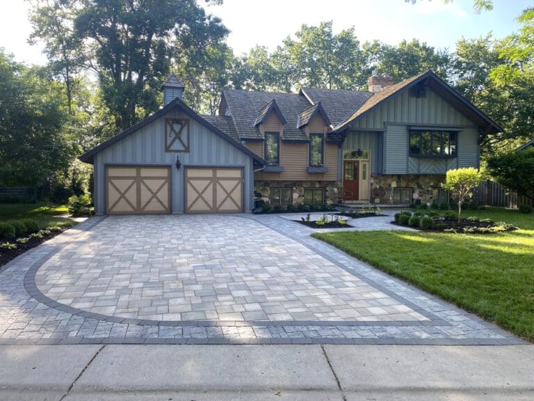 exterior of a home with a paved driveway and custom landscaping - Yellow Brick Road Pavers & Landscapes LLC