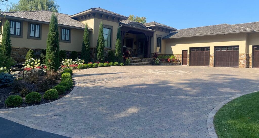 exterior of a home with a paved driveway and custom landscaping - Yellow Brick Road Pavers & Landscapes LLC