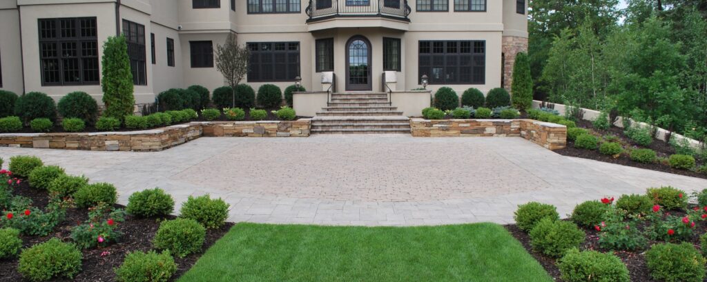 exterior of a home with a paved driveway and custom landscaping - Yellow Brick Road Pavers & Landscapes LLC