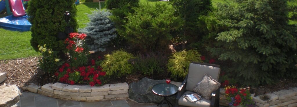 Lush garden featuring vibrant flowers and greenery, with a cozy chair and table set for relaxation, ideal for outdoor gatherings.